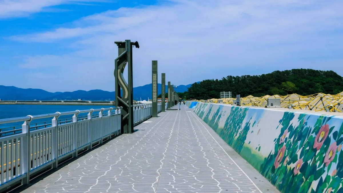 梧桐島 — 花の壁画が続く海辺の道