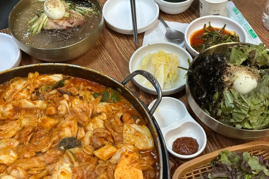 鉄板料理と麺料理、副菜を並べた食卓