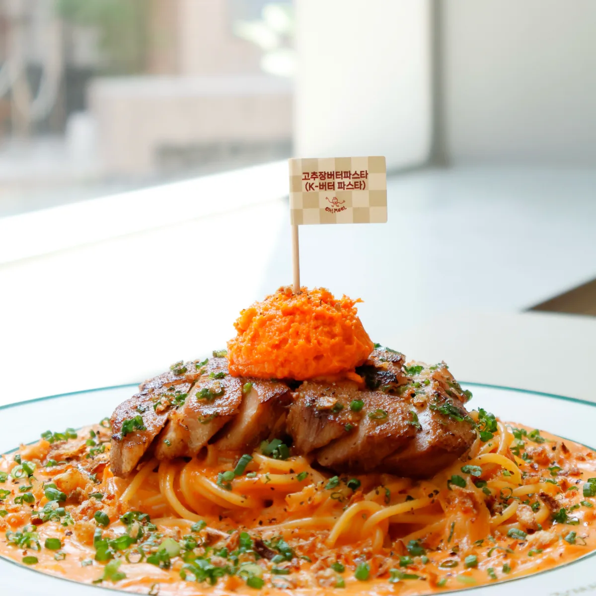 豚肉をのせた赤いソースのパスタ