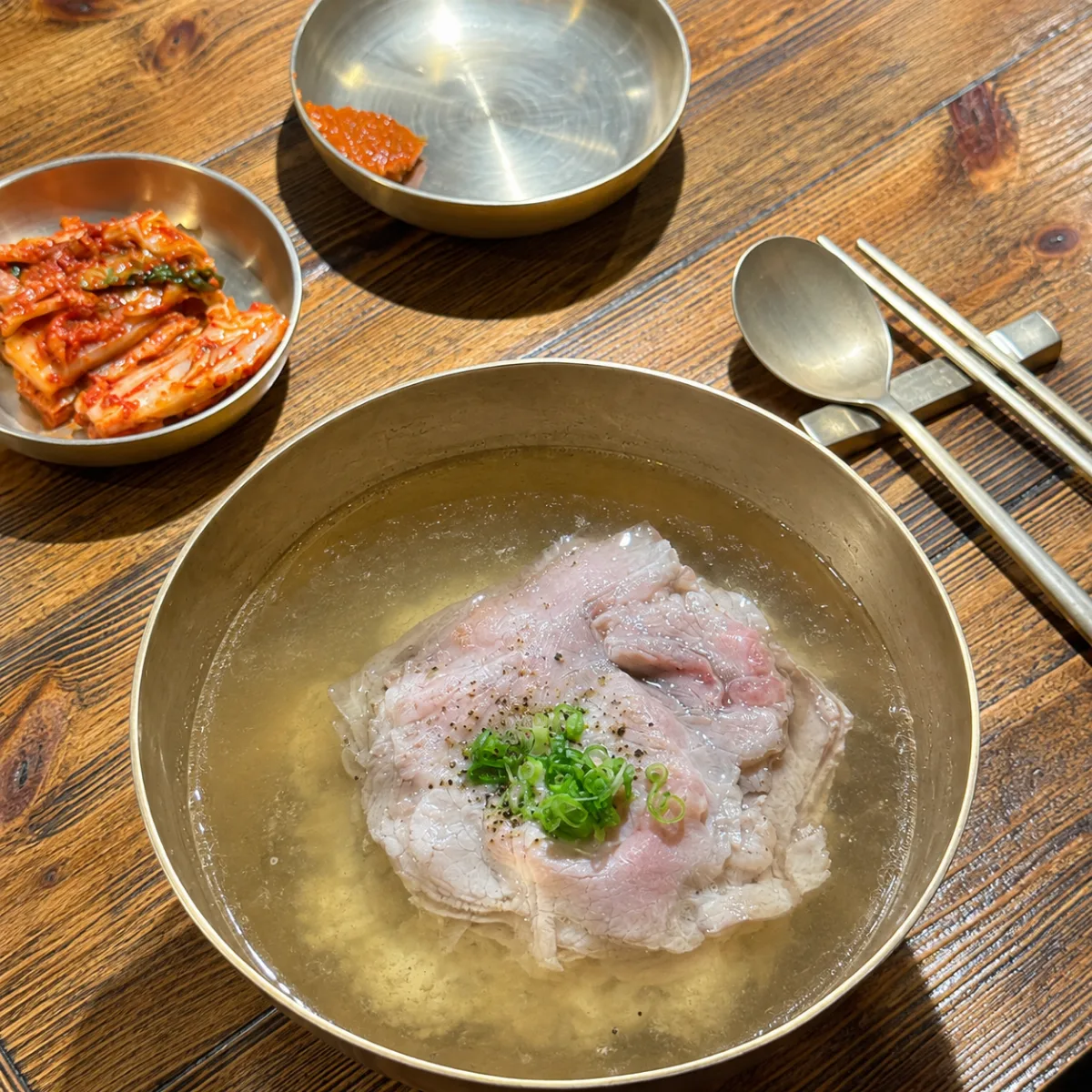 木の卓に並ぶスープとキムチの膳