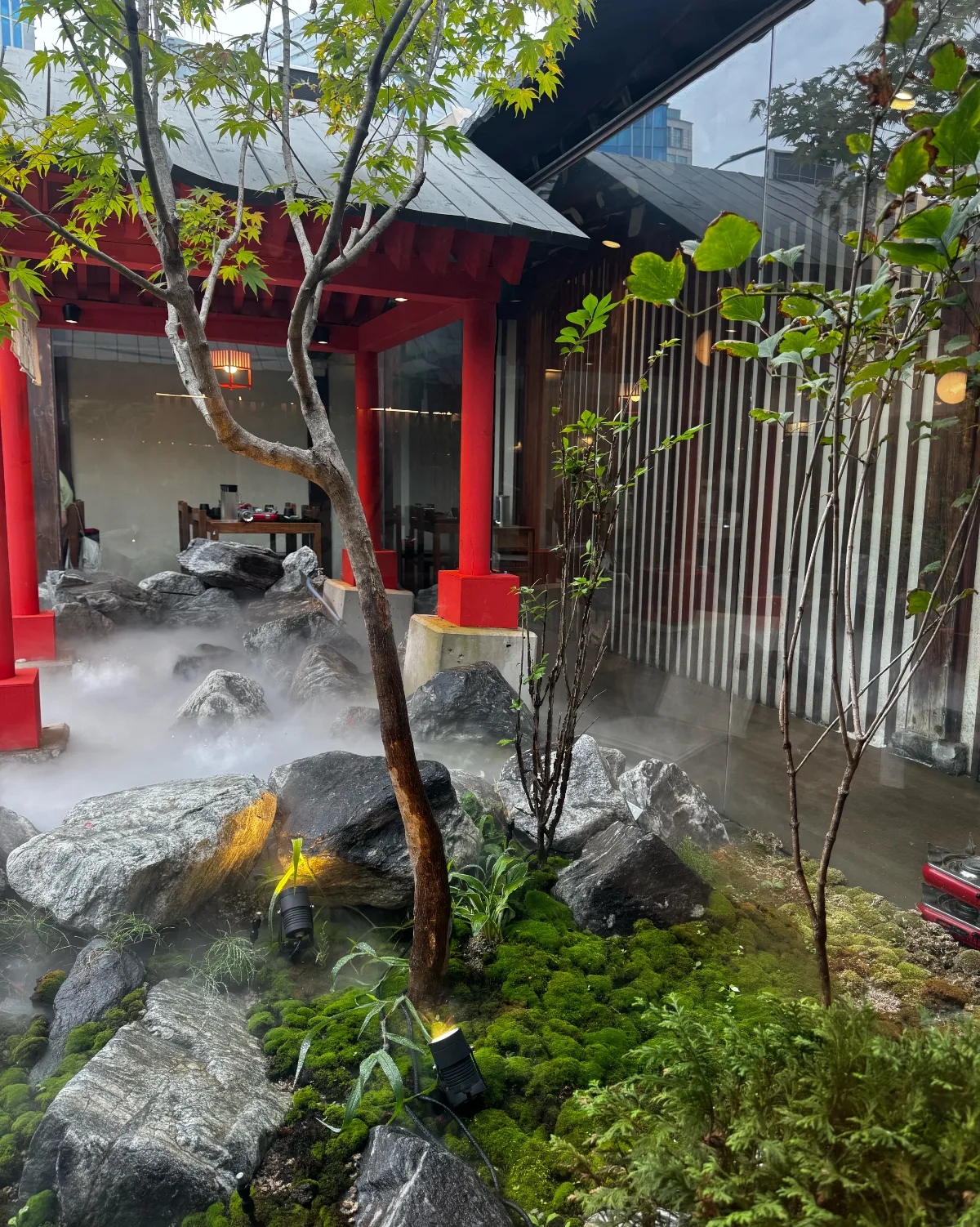 温泉家 益善店 — 赤い柱と霧に包まれた石庭