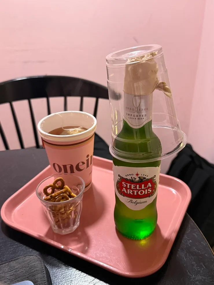 ピンクのトレーにのったカップと瓶ビール