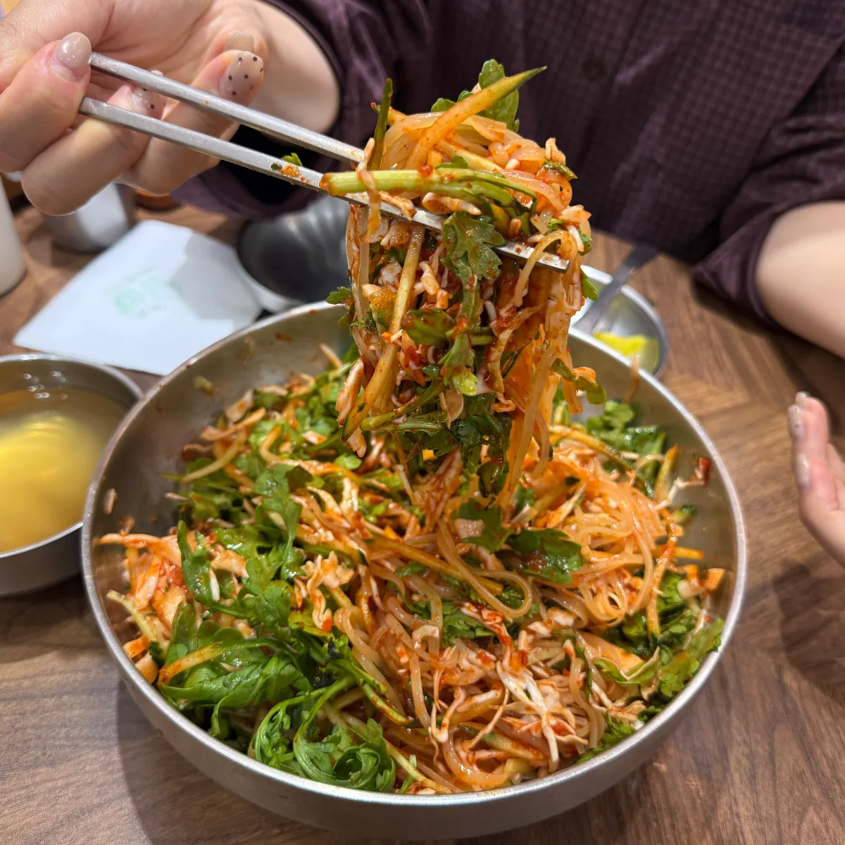 野菜と混ぜた麺を箸で持ち上げる