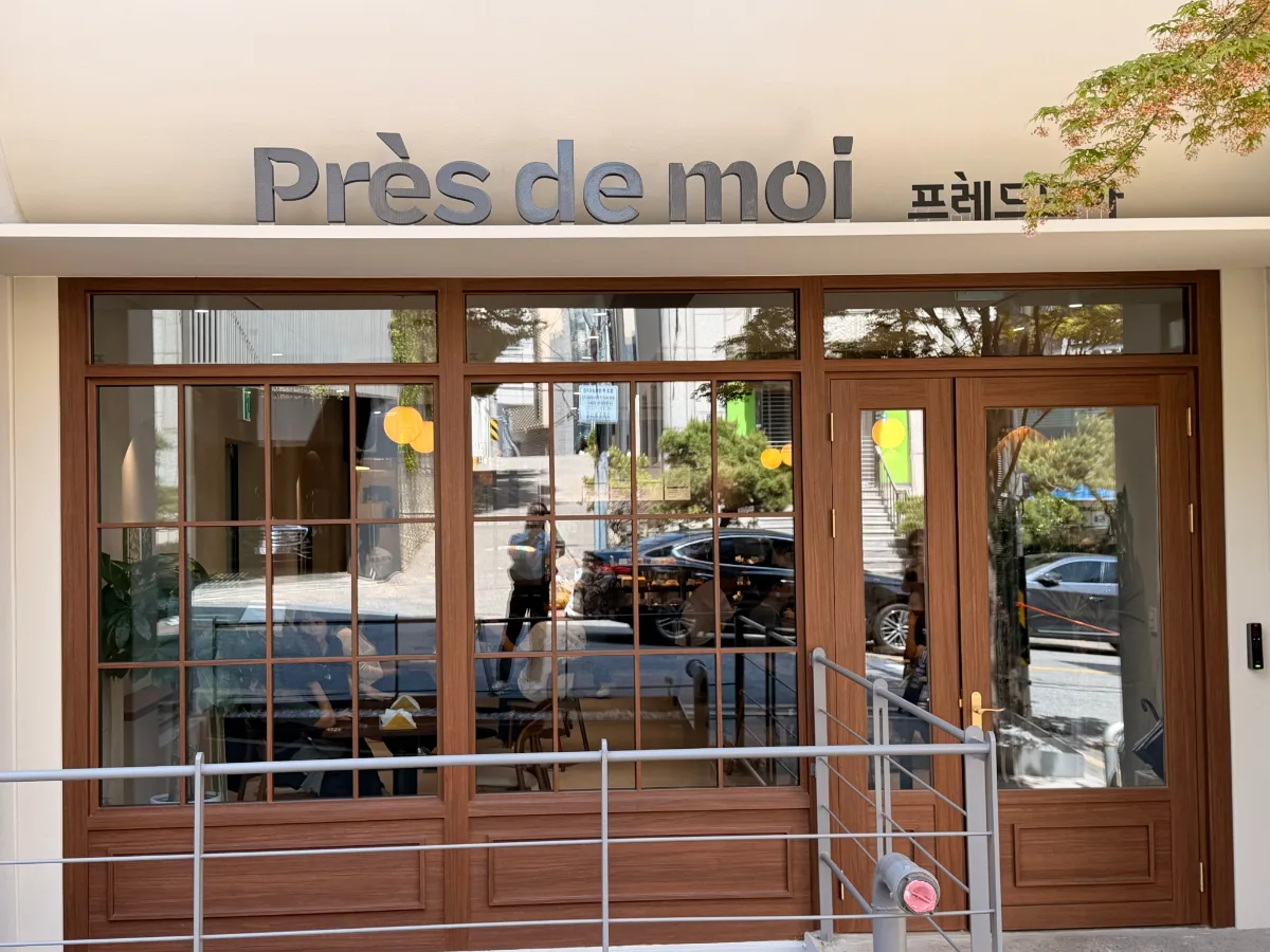 Près de Moi 論峴店 — 木枠窓と店名看板の店舗