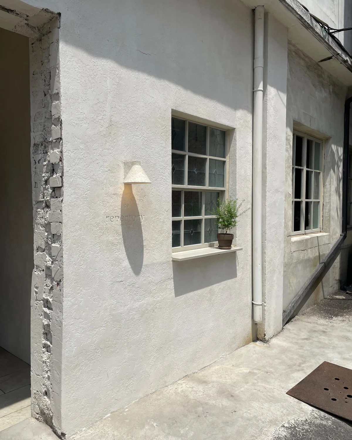 店名と鉢植えのある白壁