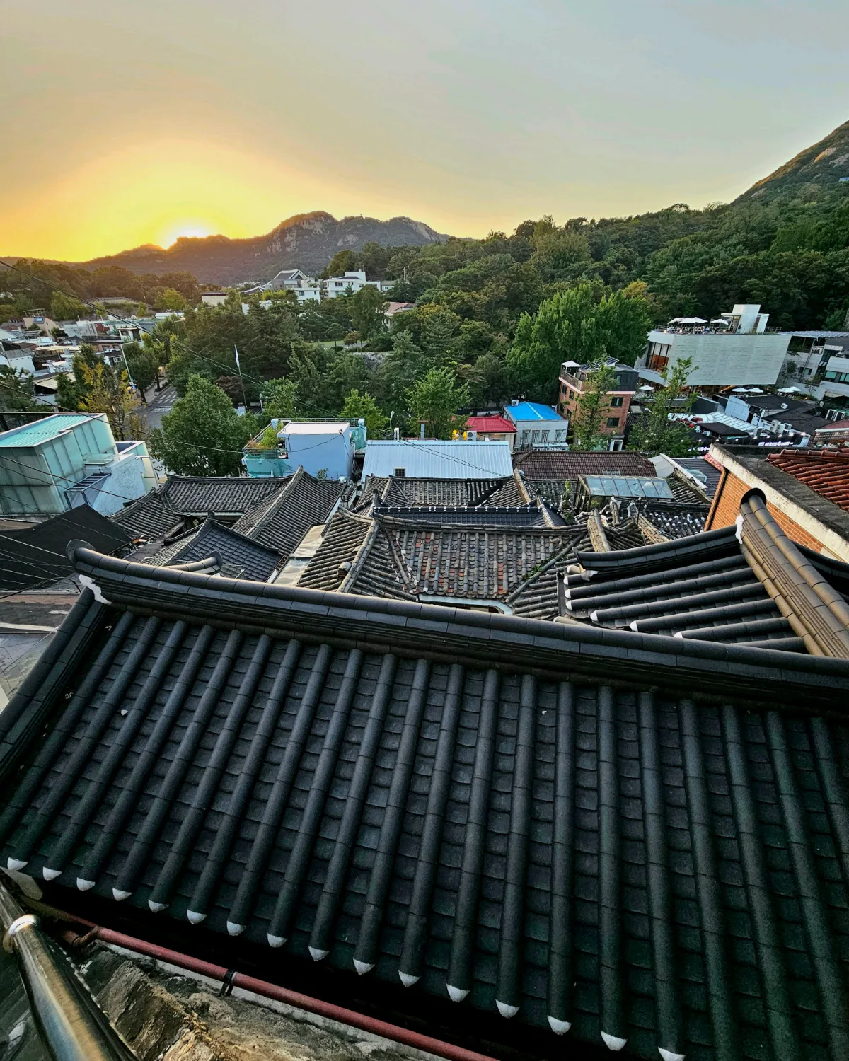 夕日に染まる瓦屋根と山