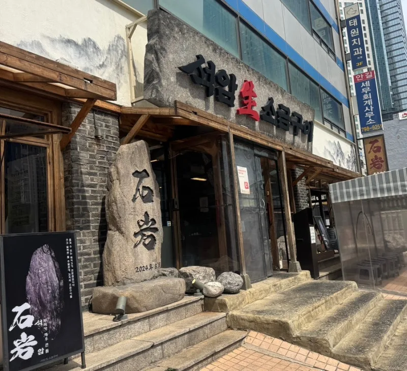 石岩の石碑がある店舗外観