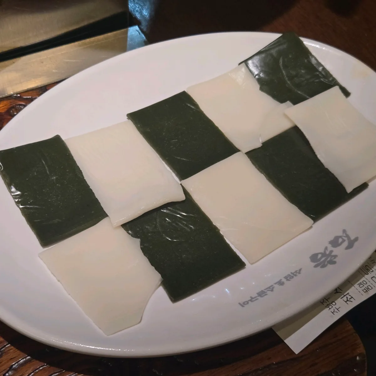 白いチーズと黒い海苔を交互に並べた皿