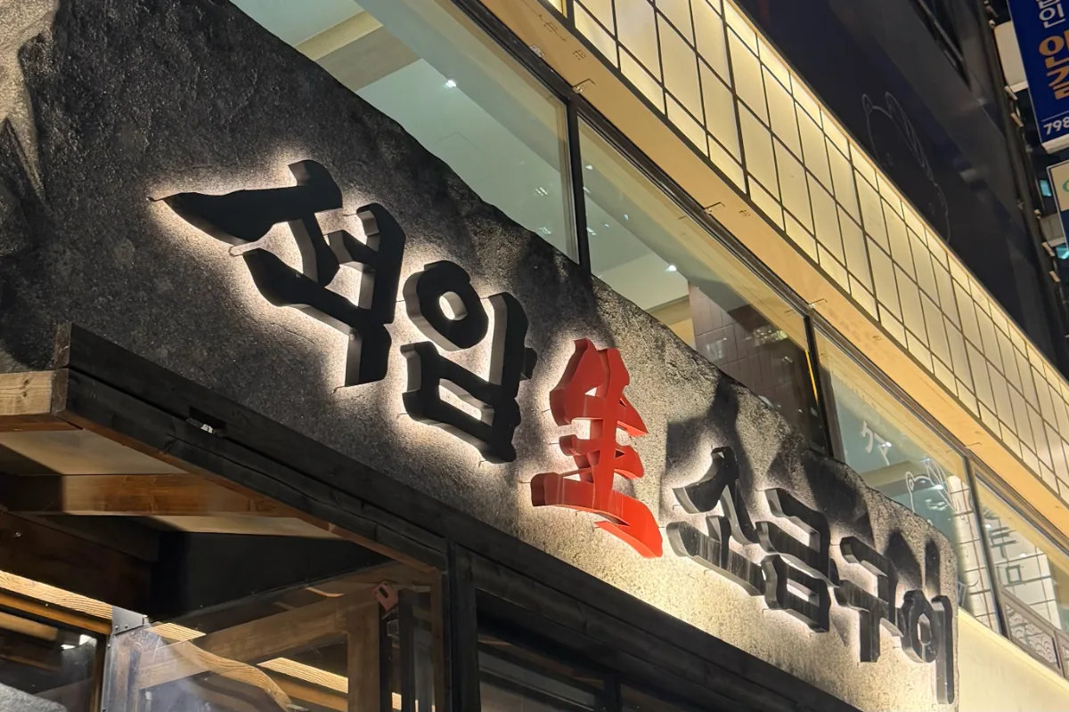 岩肌の看板に浮かぶ店名の文字