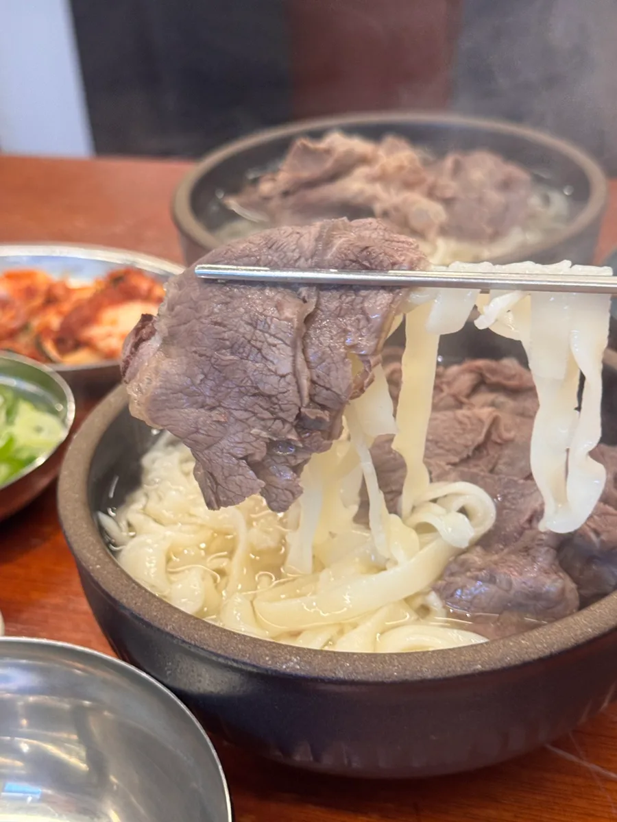 箸で持ち上げた牛肉と麺