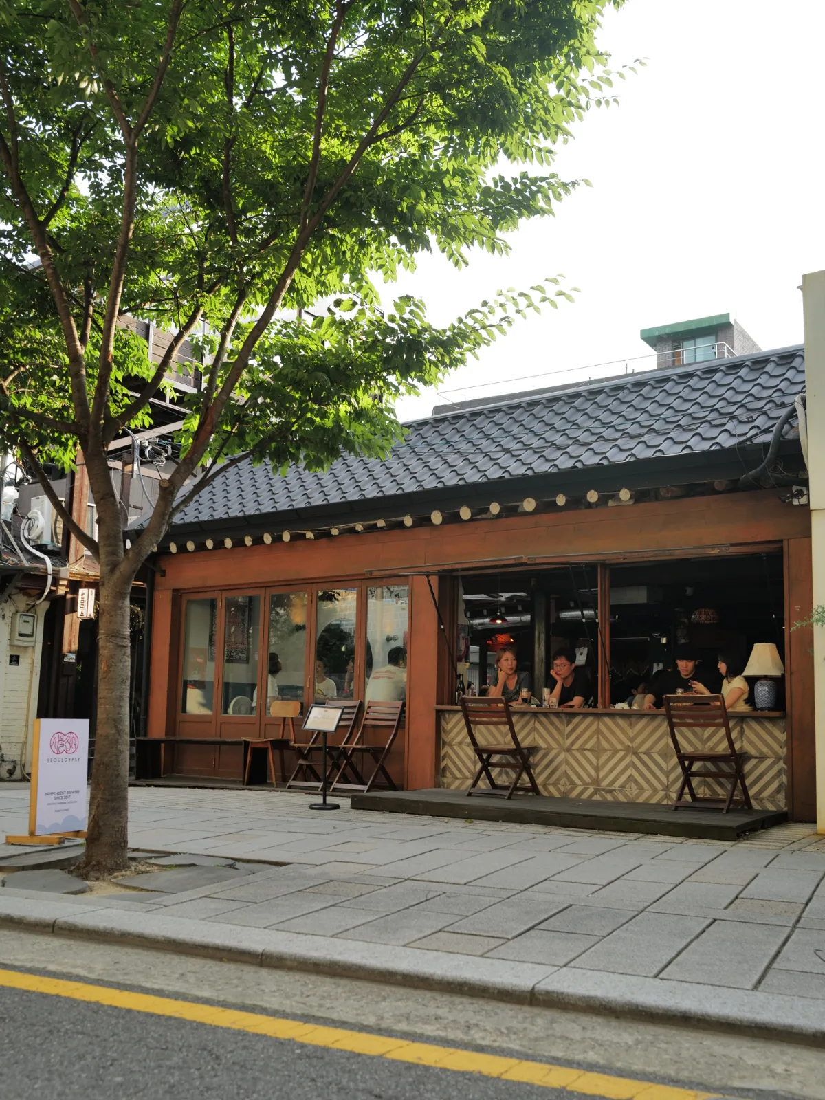 木陰に建つ瓦屋根の店舗