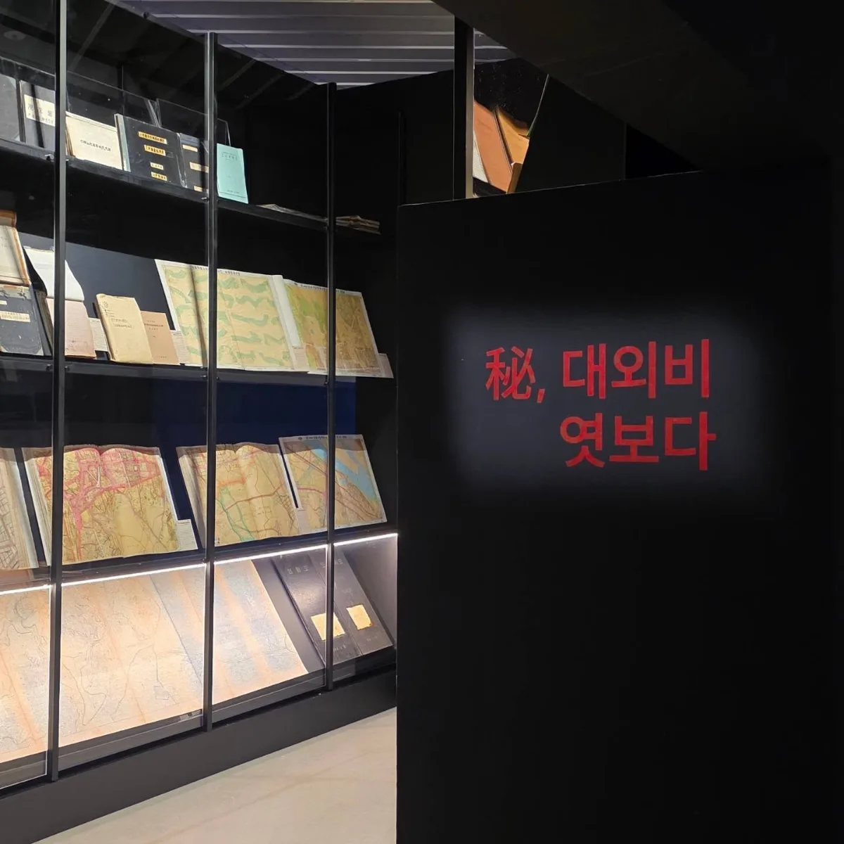古地図が並ぶ暗い展示棚