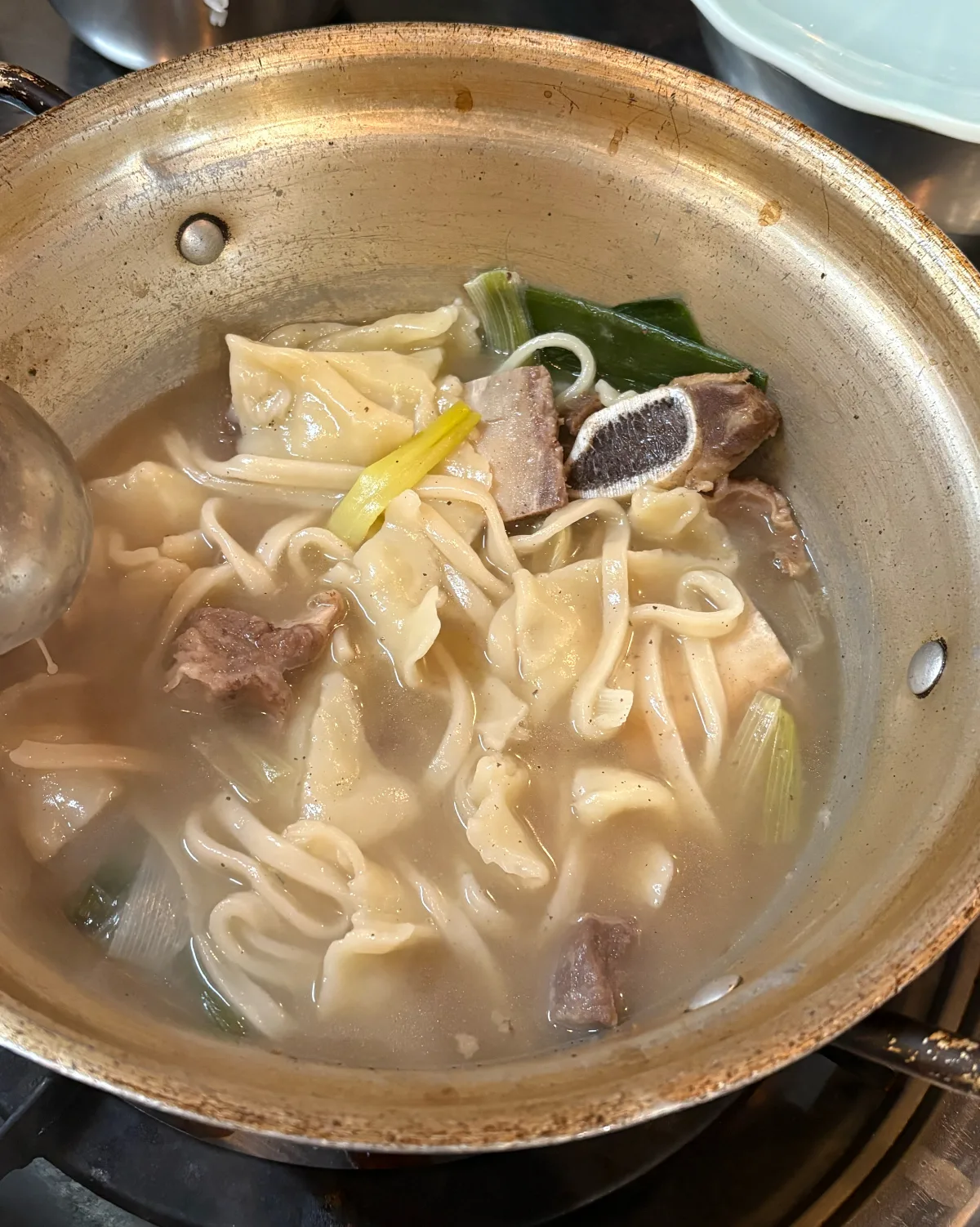 鍋の中の餃子と麺と肉