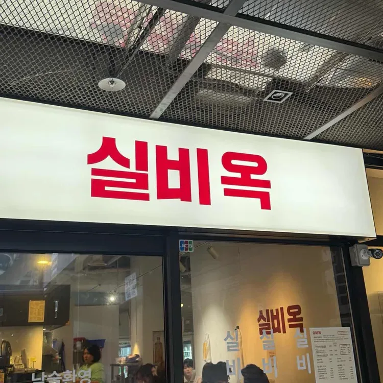 赤い店名看板と入口のガラス扉