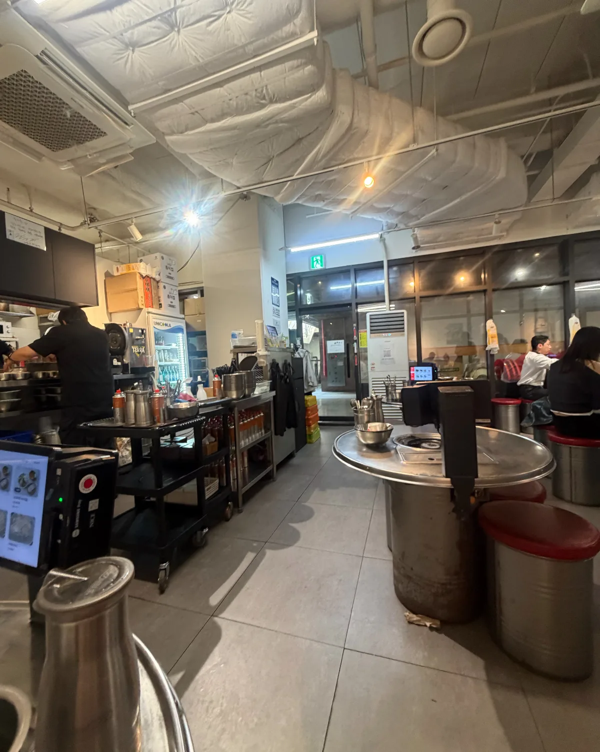 赤いスツールと丸い鉄板卓の店内