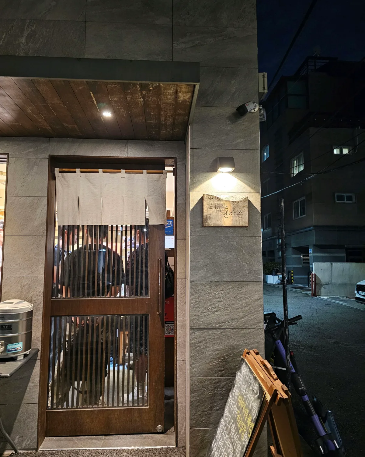 暖簾と看板が掛かる夜の店構え