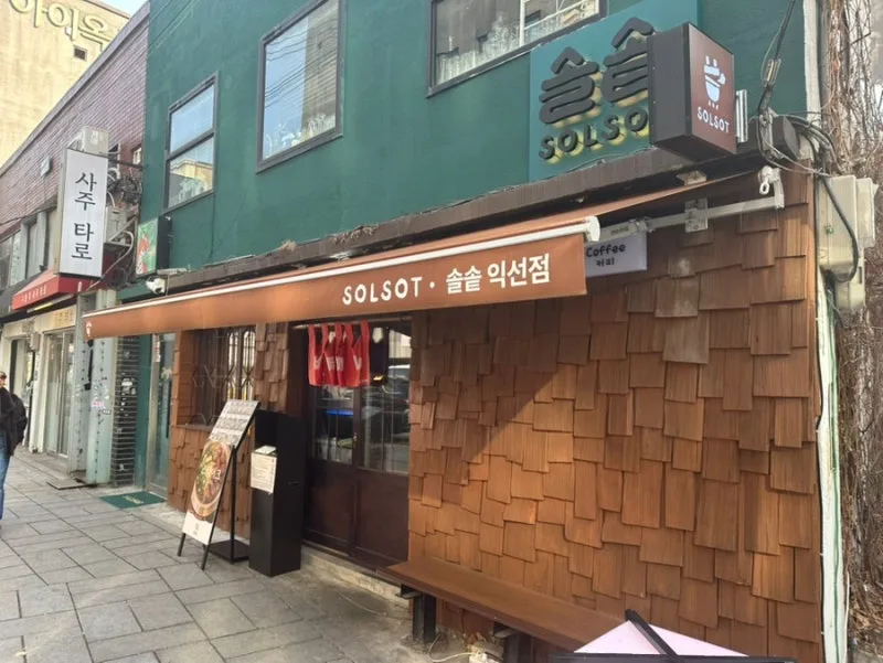 木板壁と緑のソルソッ店舗