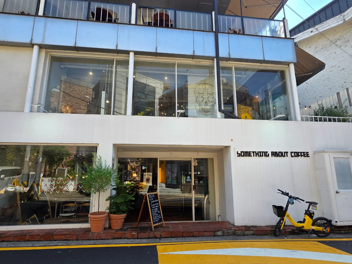SOMETHING ABOUT COFFEE — 店名が掲げられた白い建物