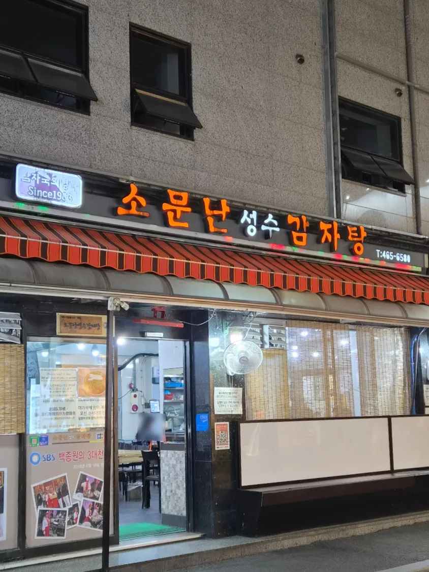 橙色の店名看板と縞の日よけ
