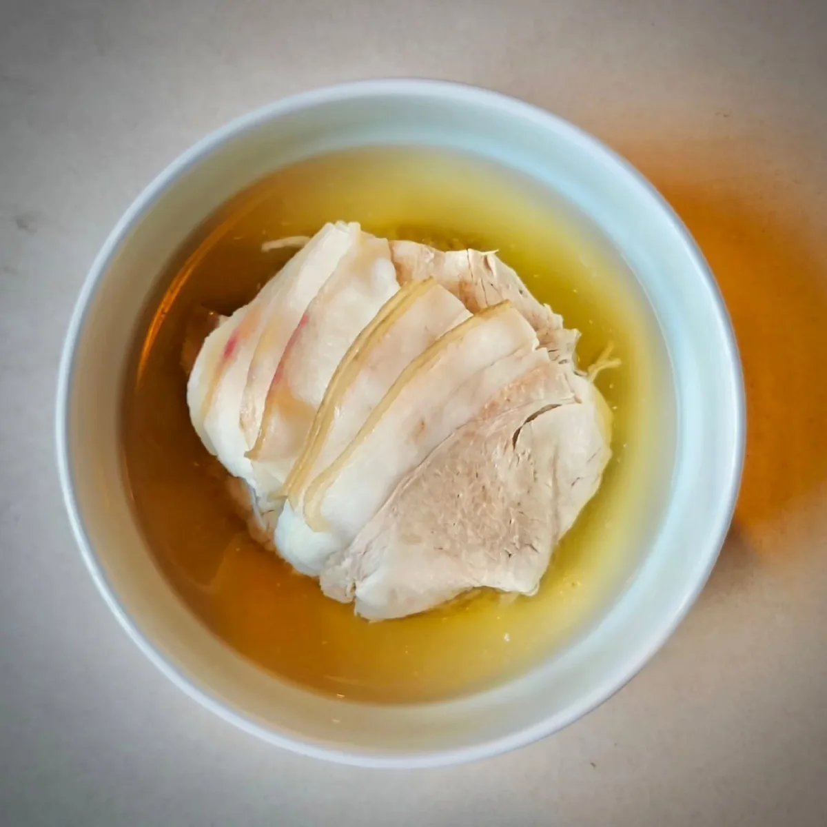 澄んだスープに重なる薄切り豚肉