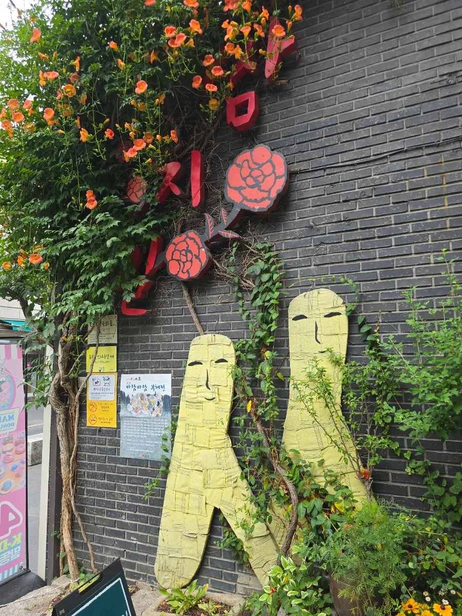 花と人形のレンガ壁