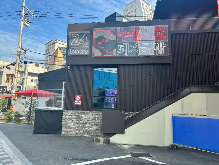 水辺最高テジクッパ 広安店 — 黒い外壁とネオン看板の店舗
