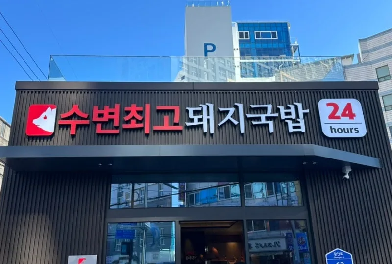 赤い看板文字と黒い外壁の店構え