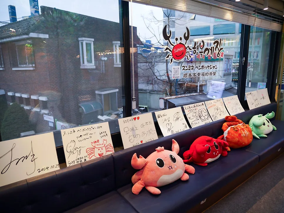 蟹のぬいぐるみとサイン色紙が並ぶ待合ベンチ