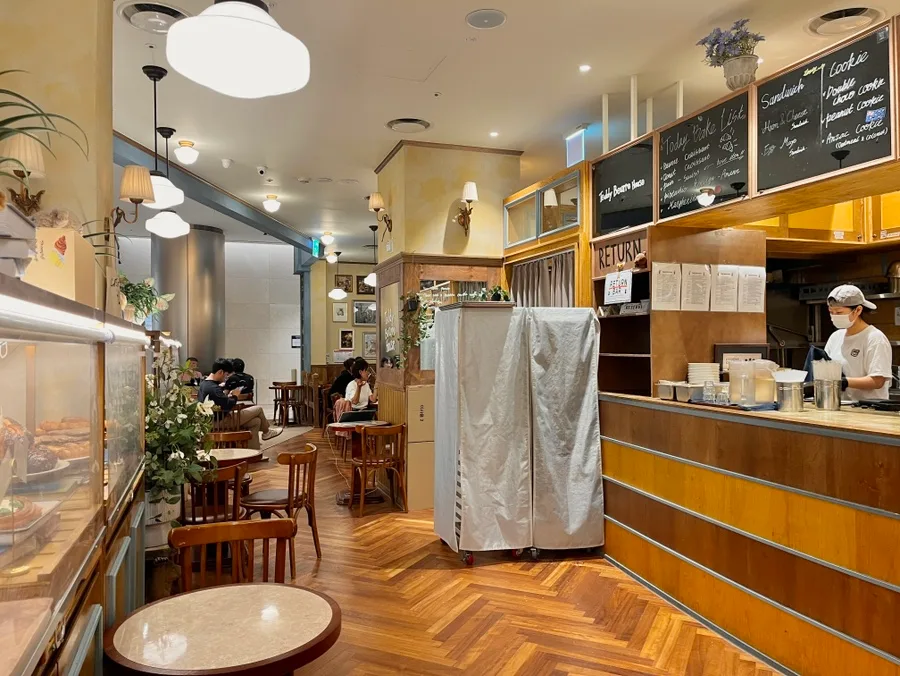 Teddy Beurre House ロッテワールドモール店 — 木の床と丸テーブルが並ぶ店内