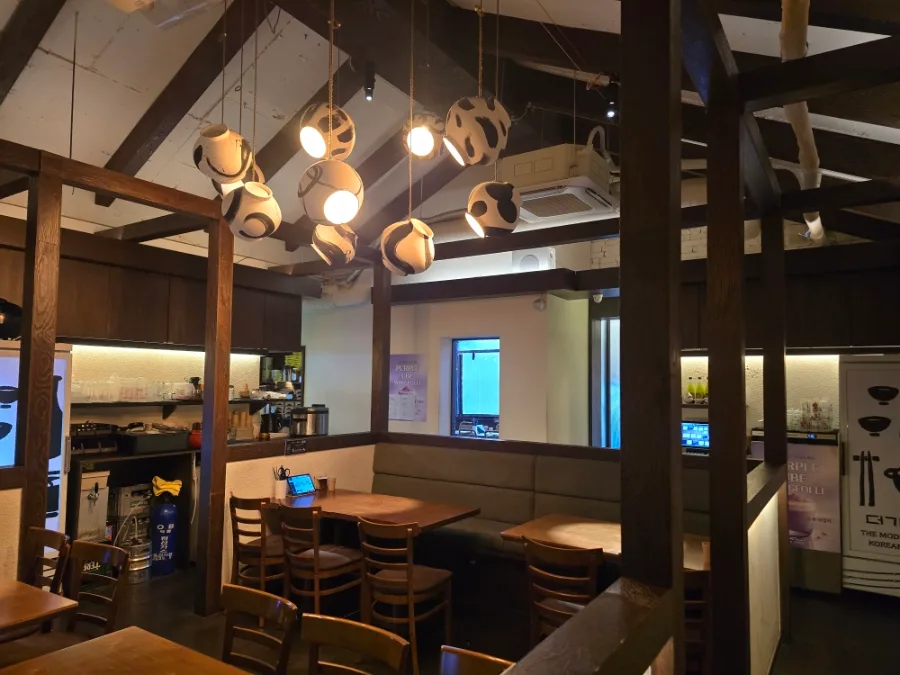 THE GIWA 合井店 — 木の梁と照明がある客席