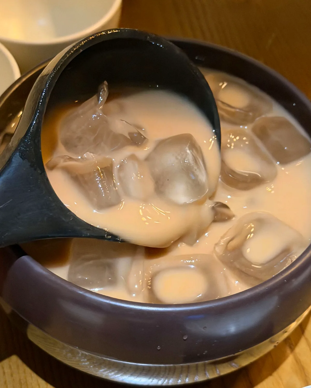 氷を浮かべたマッコリをひしゃくですくう