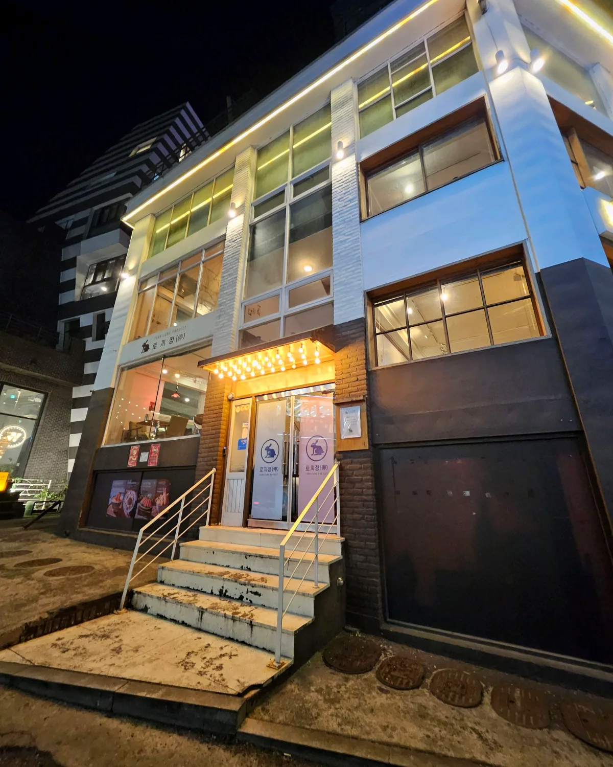 夜の白い3階建ての建物と入口の階段