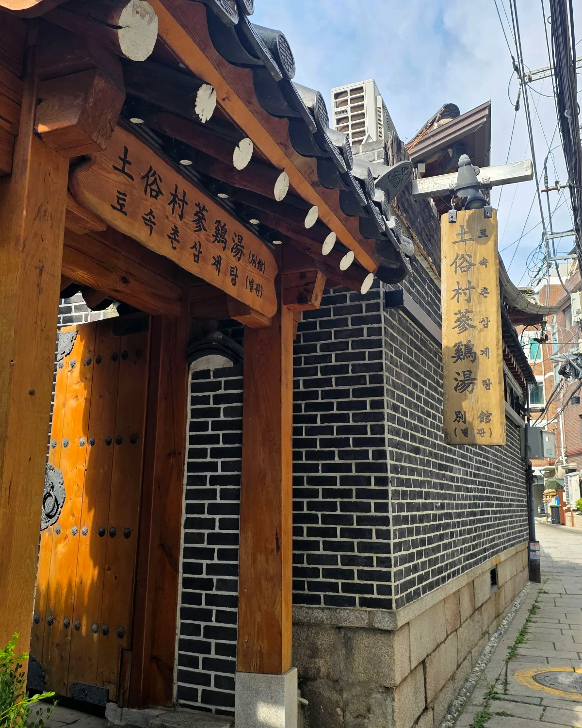 別館の木製看板と煉瓦塀