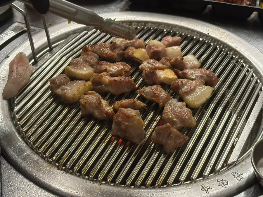 トングで焼く豚肉の角切り