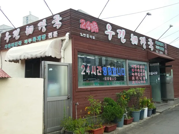 店名看板と鉢植えのある店舗