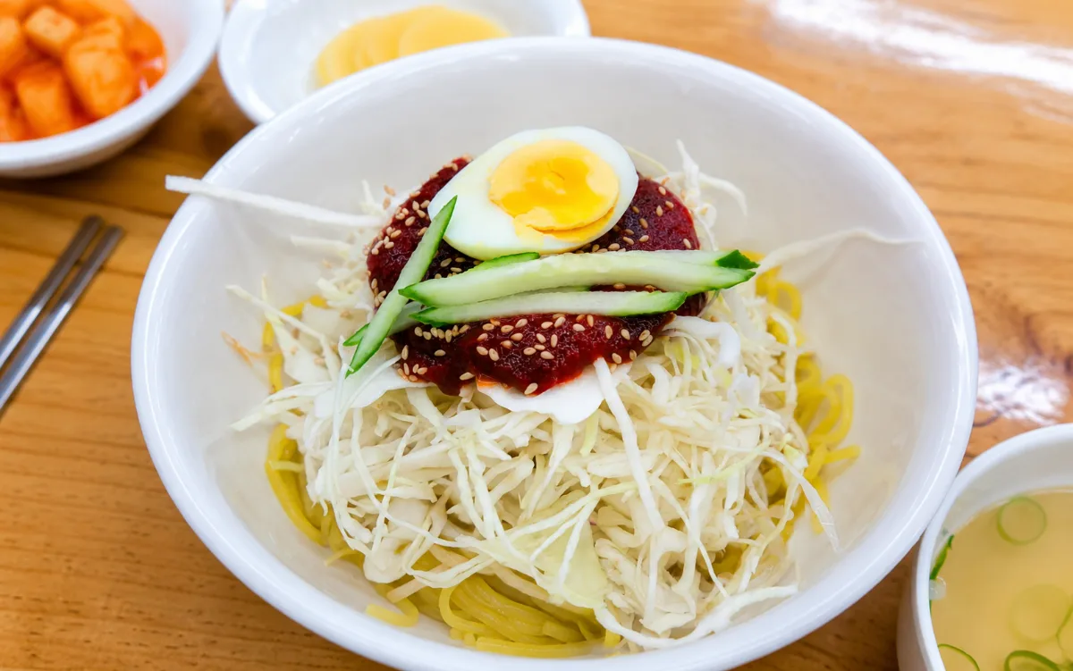 千切り野菜とゆで卵を盛った辛味麺