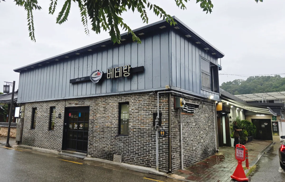 ベテランカルグクス — 雨に濡れた黒煉瓦の店舗