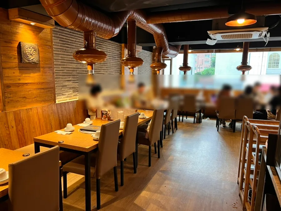 王妃家 明洞本店 — 排煙フードが並ぶ客席