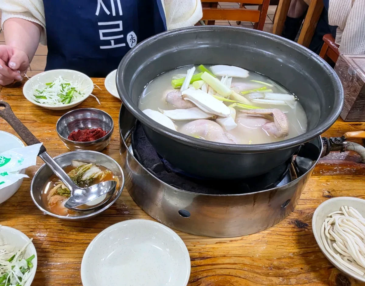 元祖ウォンハルメ・ソムンナン・タッカンマリ — 鶏鍋と麺、薬味が並ぶ食卓