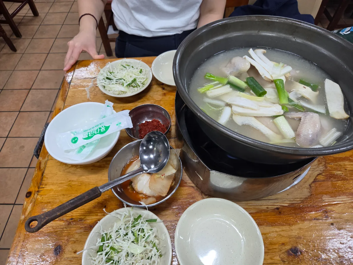 元祖ウォンハルメ・ソムンナン・タッカンマリ — 鶏鍋と薬味が並ぶ食卓