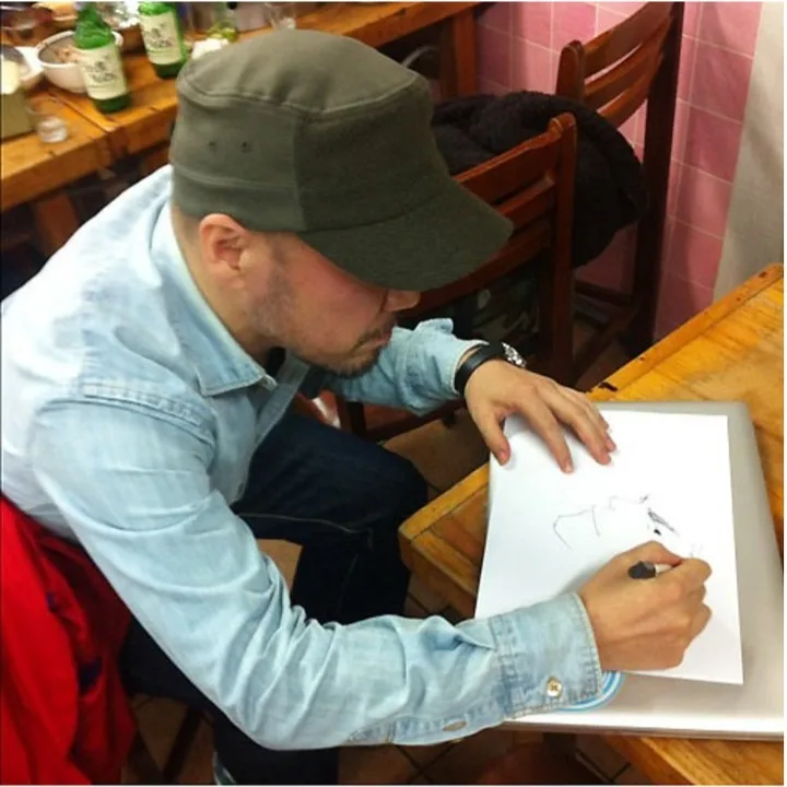 店のテーブルで絵を描く井上雄彦さん（店の公式Instagramより）