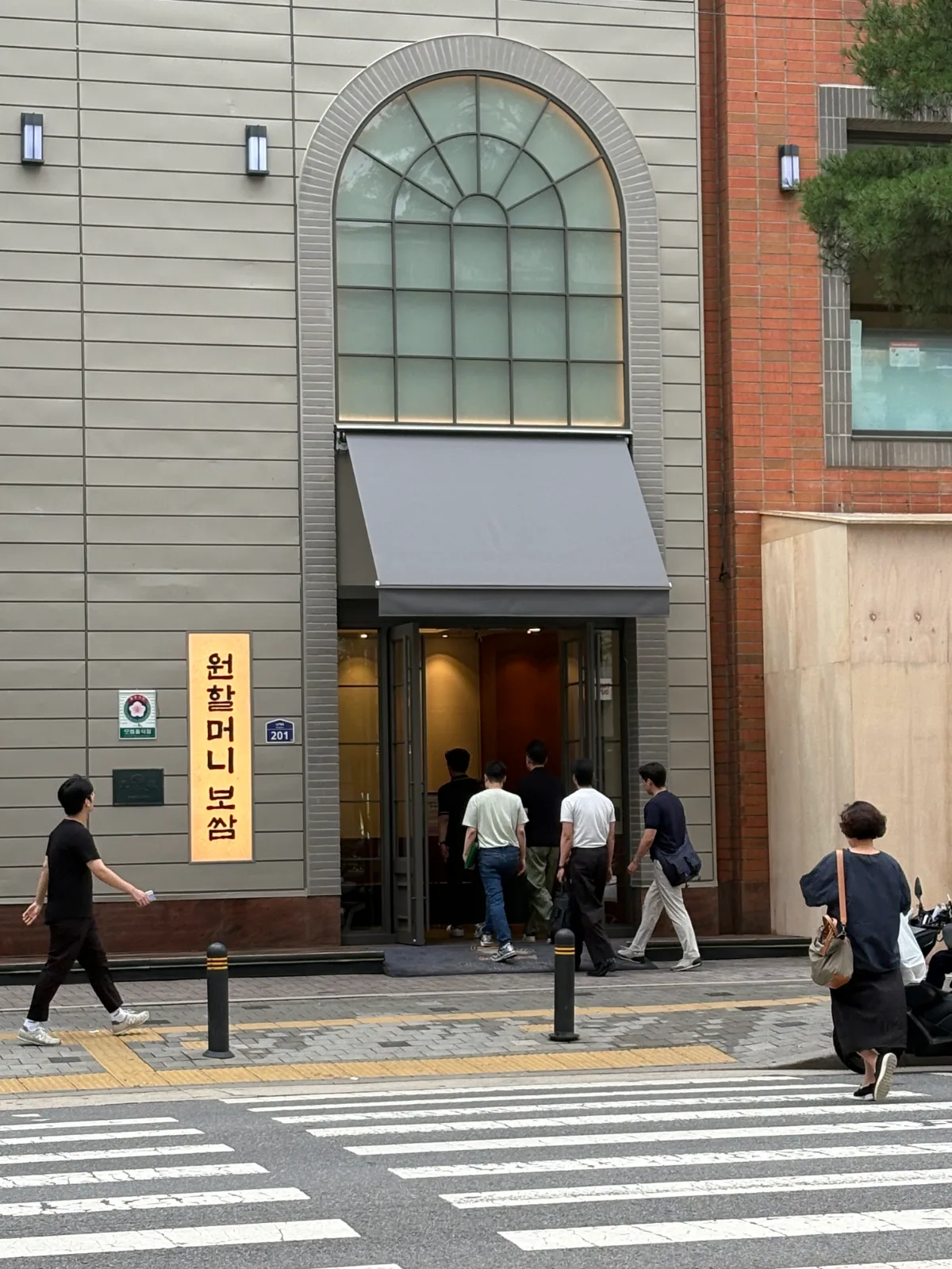 ウォンハルモニポッサム・チョッパル 本店 — アーチ窓と縦看板の店先