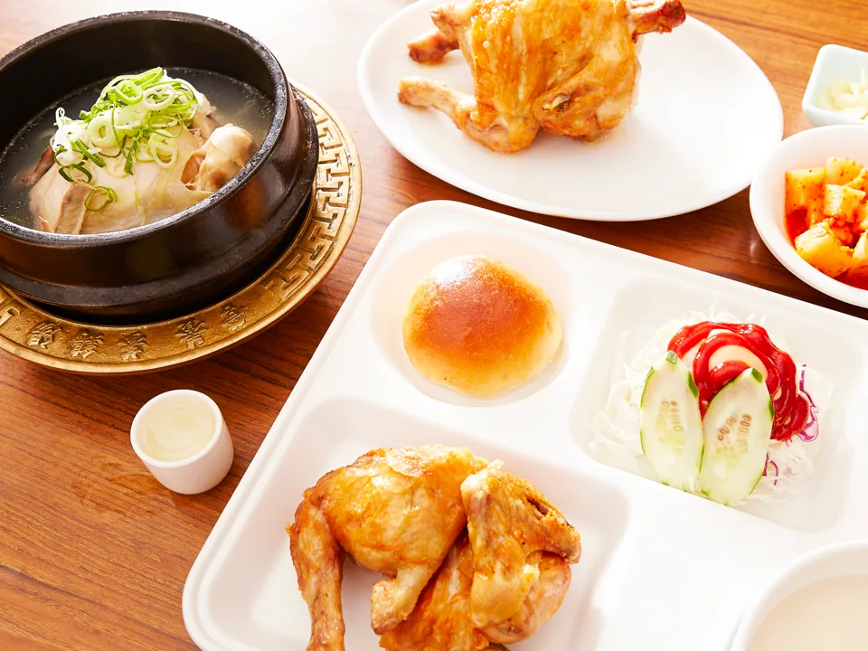丸鶏とスープ、副菜が並ぶ食卓