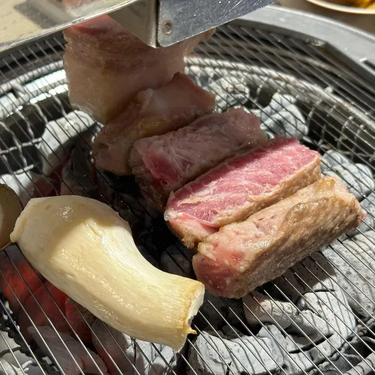 網で焼く厚切りの豚肉