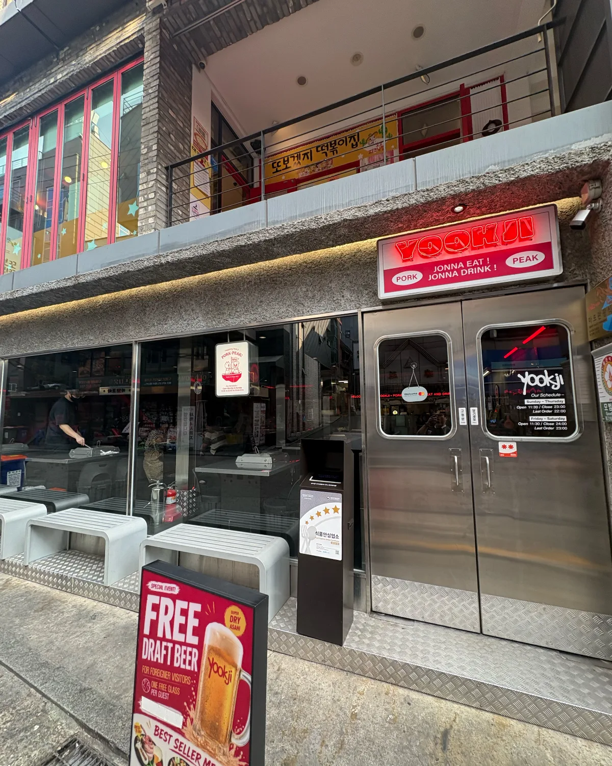 ホンデユクジ — 赤い看板と金属扉の店先