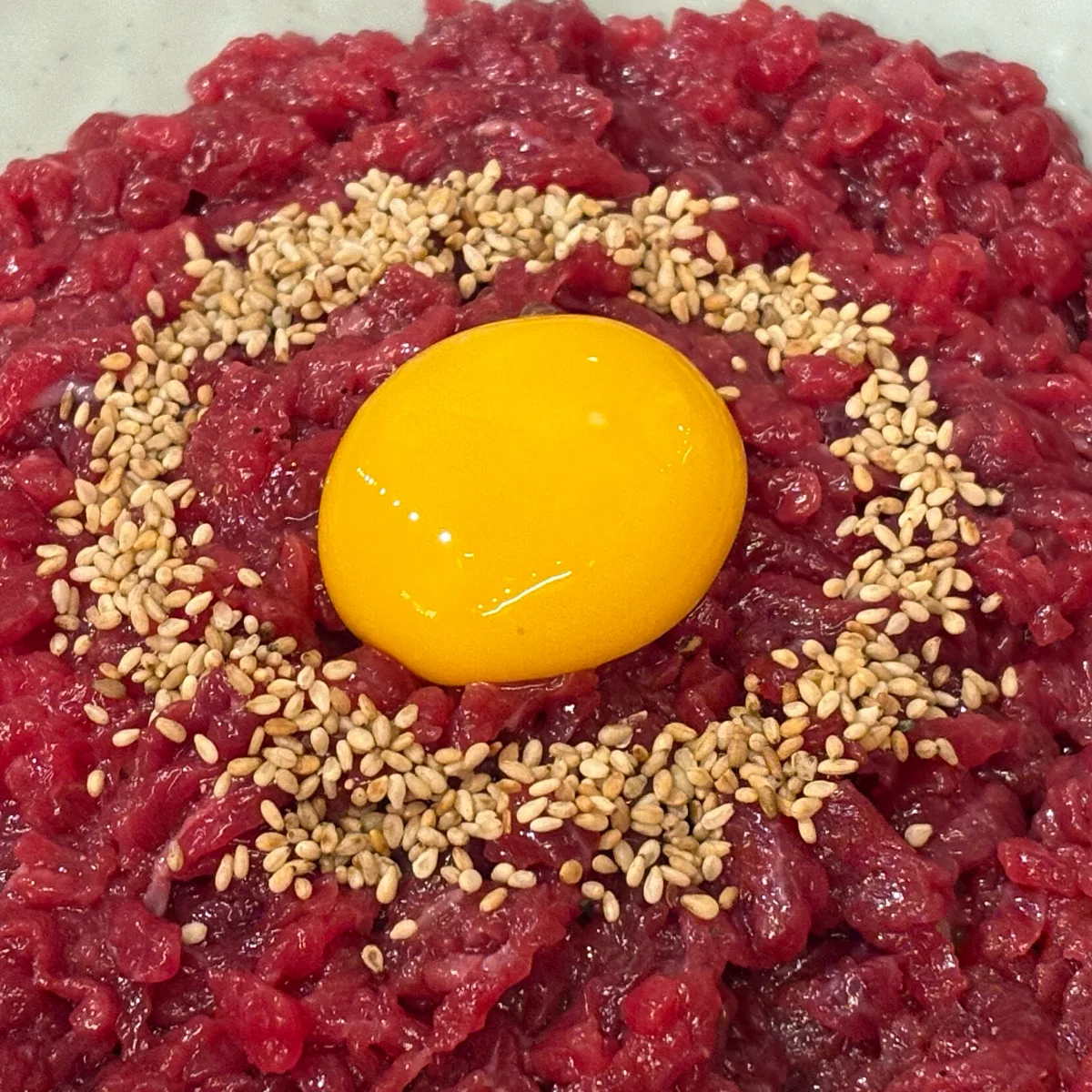 ユッケチャメチッ 本店 — 卵黄とごまを添えた生牛肉