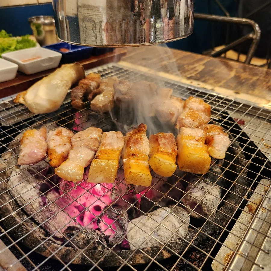 炭火の上で焼ける厚切り豚バラ